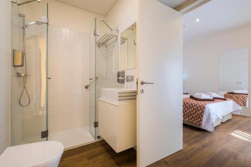 un letto e un bagno con doccia e servizi igienici. di Casas Amarelas Azores a Ponta Delgada