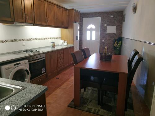 eine Küche mit einem Tisch und Stühlen in einer Küche in der Unterkunft Retiro do Caçador in Reguengos de Monsaraz