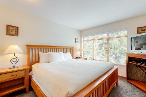 1 dormitorio con 1 cama grande y TV en Northstar at Stoney Creek, en Whistler