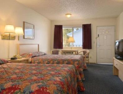 a hotel room with two beds and a television at Super 8 by Wyndham Susanville in Susanville