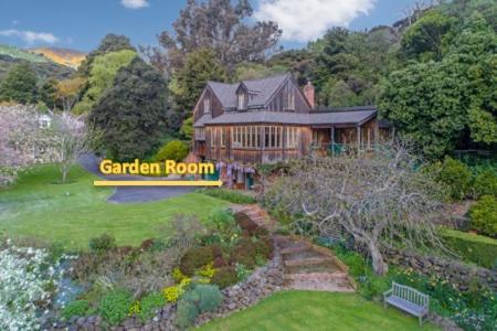 a house with a garden room sign in front of it at Mill Cottage - boutique accommodation and garden in Akaroa