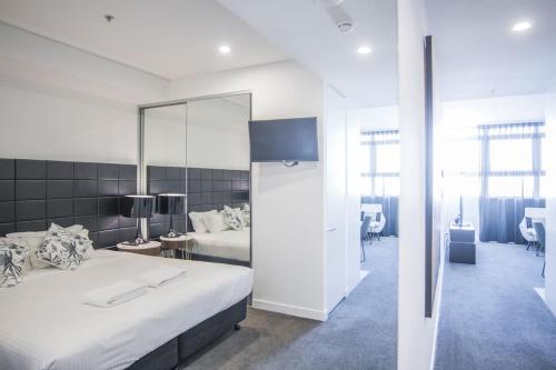 a bedroom with a large white bed and a mirror at Train Station Access! 1Bed1Bath APT at Chatswood in Sydney