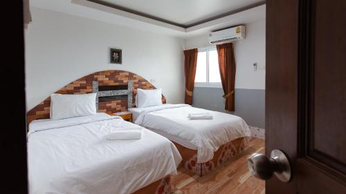 um quarto de hotel com duas camas com lençóis brancos em KritshanaJPR 3 K Hotel em Trat