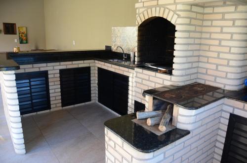 a kitchen with a brick oven with a stove at Casa em penedo in Penedo