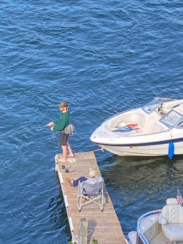 a child standing on a dock next to a boat at THE INN Bigfork Bay in Bigfork