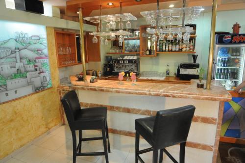 un bar con sillas negras en un restaurante en Tabar Hotel en Nazareth
