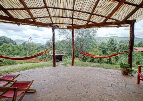 a patio with hammocks and a view of the mountains at Finca La Vispera in Samaipata