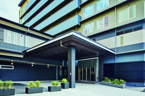 a building with potted plants in front of it at Kowakuen Haruka in Matsuyama