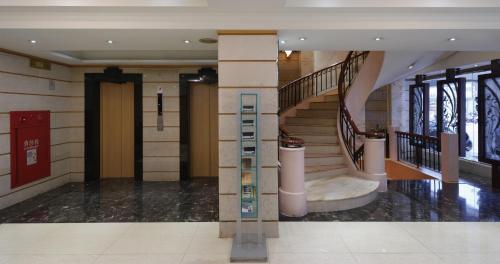 a lobby with a staircase and a stair case at K Hotel Keelung in Keelung