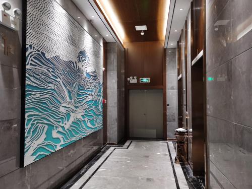 a hallway with a painting on the wall at Ramada Encore by Wyndham Chenzhou North in Zixing
