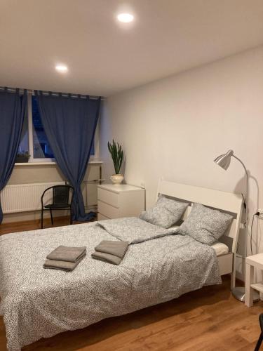 a bedroom with a large bed with blue curtains at apartamenti Zirnis in Cēsis