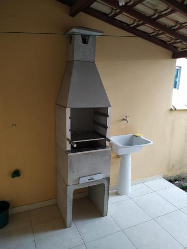 a kitchen with a stove and a sink at Casa Unamar Cabo Frio/RJ. in Cabo Frio