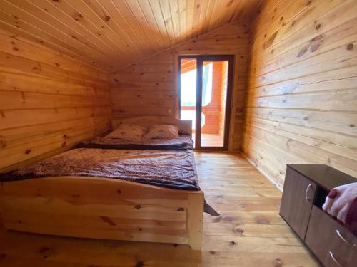 a log cabin bedroom with a bed in it at Берег Світязя in Svityazʼ