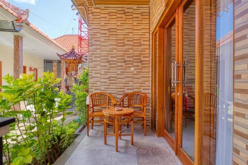 a small patio with a table and chairs on it at Nibugi Guest House in Nusa Penida