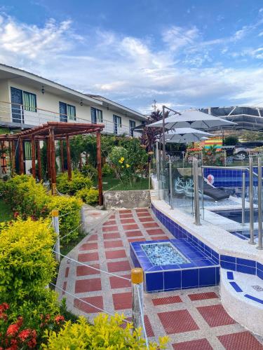 a pool with an umbrella next to a building at HV Sueño Real Tatacoa in Villavieja