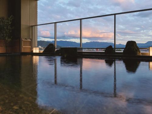 a group of people sitting in front of a pool of water at Kowakuen Haruka in Matsuyama
