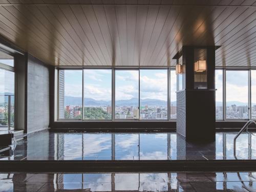 a large room with a large window and a pool at Kowakuen Haruka in Matsuyama