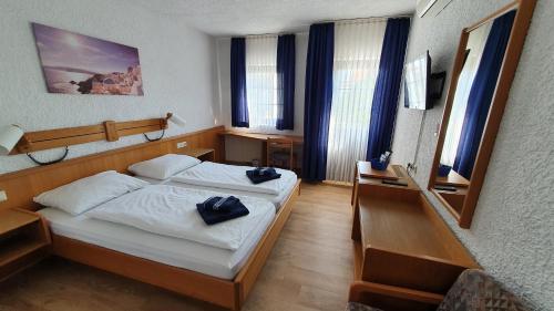 a bedroom with a bed with towels on it at Prestige Bistro & Pension in Pfungstadt