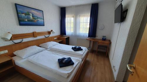 a hotel room with two beds and a television at Prestige Bistro & Pension in Pfungstadt