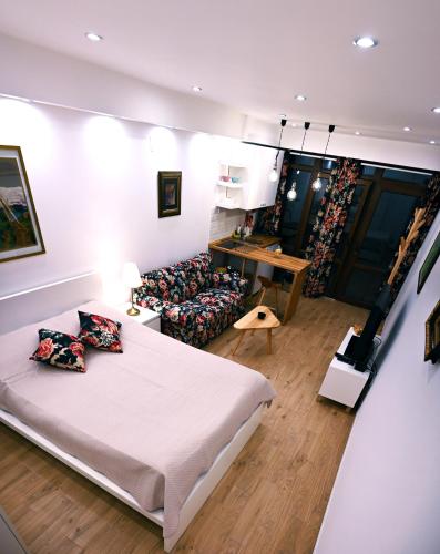 a bedroom with a bed and a couch at Apartman Andric 2 in Valjevo