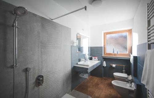 a bathroom with a sink and a toilet and a shower at Dolce Vita Apartment in Valdaora