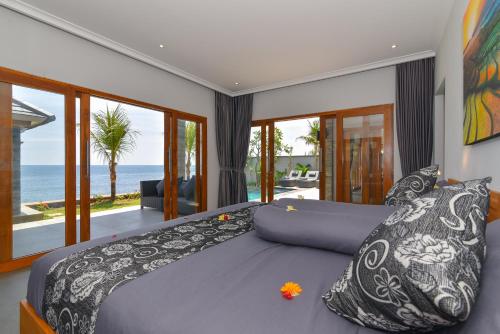 a bedroom with a bed with a view of the ocean at Villa Sean in Lovina