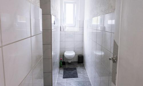 a white bathroom with a toilet and a window at Work & Stay in Villingen-Schwenningen in Villingen-Schwenningen