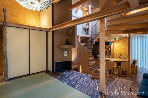 ARCHITEKTON -the villa Tennoji- في أوساكا: غرفة معيشة مع درج وغرفة طعام