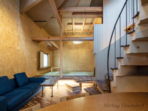 a living room with a blue couch and a table at ARCHITEKTON -the villa Tennoji- in Osaka