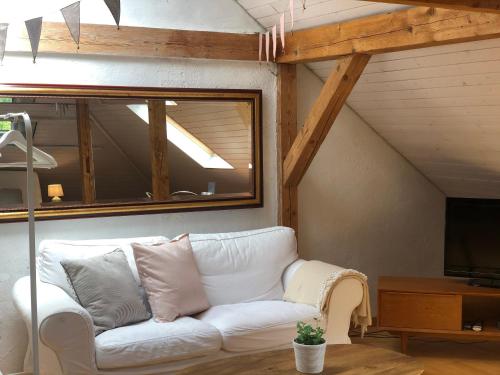sala de estar con sofá blanco y TV en The Bed + Breakfast en Luzern