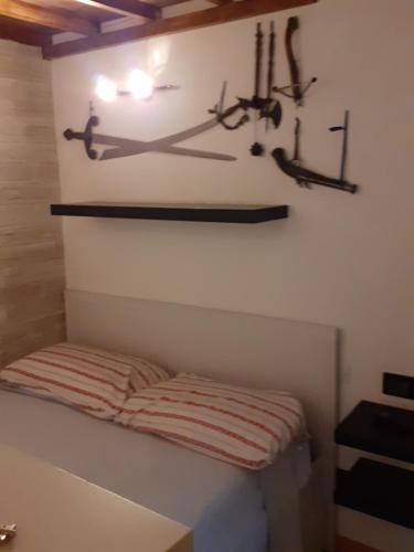 um quarto com uma cama e algumas armas na parede em CASA GIOVANNI em Milão