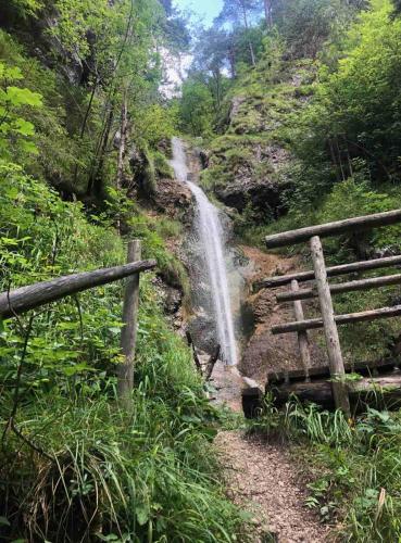 a waterfall on the side of a mountain with a fence at Apartma LUPIS in Podvolovljek