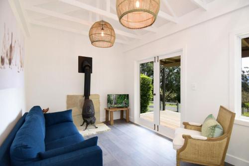 a living room with a blue couch and a fireplace at Maple Cottage in Kangaroo Valley