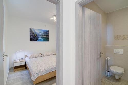a small bedroom with a bed and a toilet at Nehaj in Senj