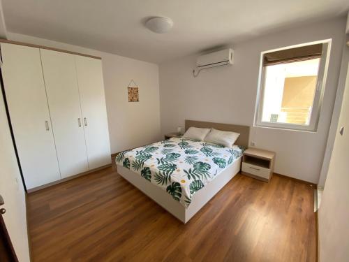 a bedroom with a bed and a window at Apartments Dione in Pomorie