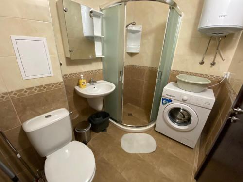 a bathroom with a toilet and a sink and a washing machine at Apartments Dione in Pomorie