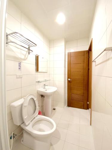 a white bathroom with a toilet and a sink at 108 House Inn in Tainan