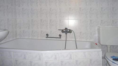 a white bath tub in a bathroom with a toilet at Pirna/Dohna, 2 R.-Wohnung in Mehrfamilienhaus in Dohna