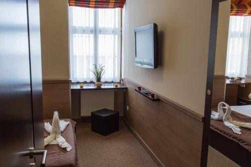 a hotel room with a tv and a window at Central Hotel 21 and Apartments in Budapest