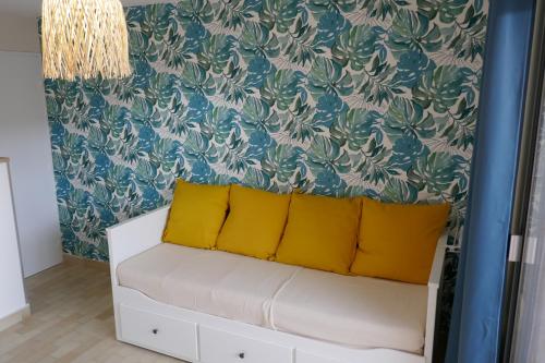 - un salon avec un canapé et des oreillers jaunes dans l'établissement Bel Appartement accès direct mer; L'Almanarre, HYERES, à Hyères