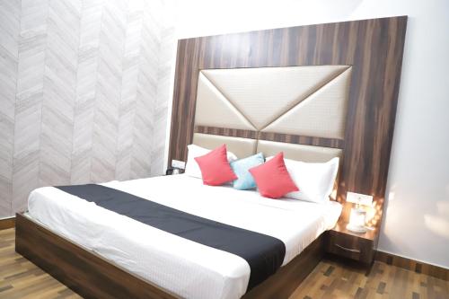 a bedroom with a large white bed with red pillows at HOTEL ROYAL ORBIT in Neemrana