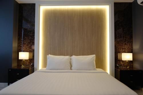 a bedroom with a bed with two lights on it at Chaisaeng Palace Hotel in Sing Buri