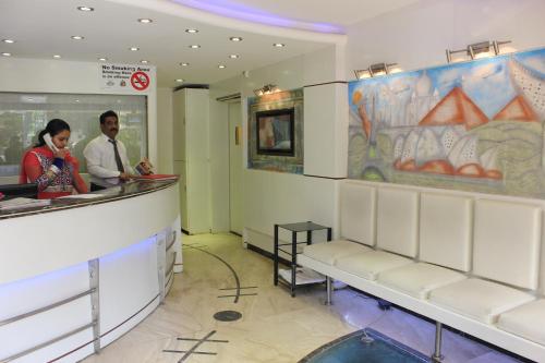 a man and woman standing at a counter in a restaurant at Hotel Fortune in Mumbai