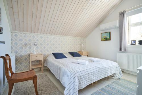 1 dormitorio con 1 cama, 1 silla y 1 ventana en Köpmans en Nauvo