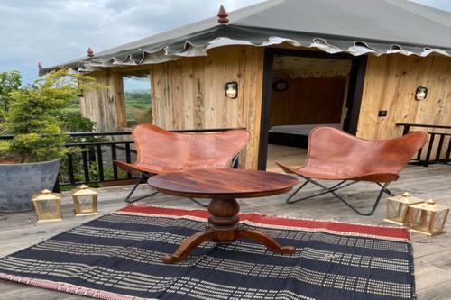 a patio with two chairs and a table and a tent at 16 Bedouin Private Pool Villa in Hosūr