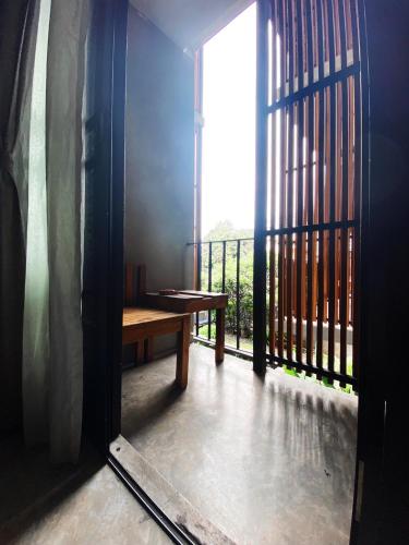 a room with a wooden table and a balcony at Lamphu House Chiang Mai in Chiang Mai