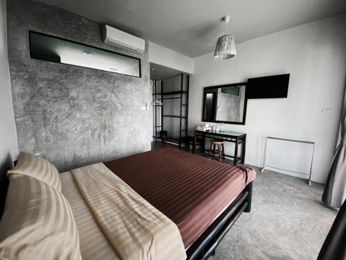 a bedroom with a bed and a desk in it at Lamphu House Chiang Mai in Chiang Mai
