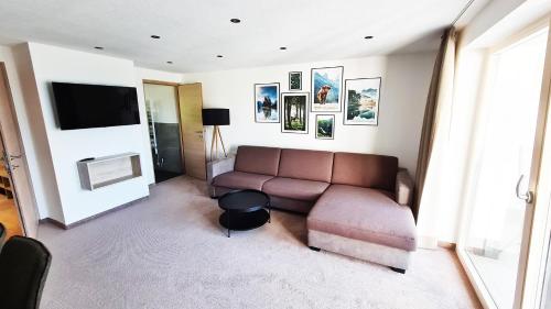 a living room with a couch and a flat screen tv at Sunshine Appartements in Fiss