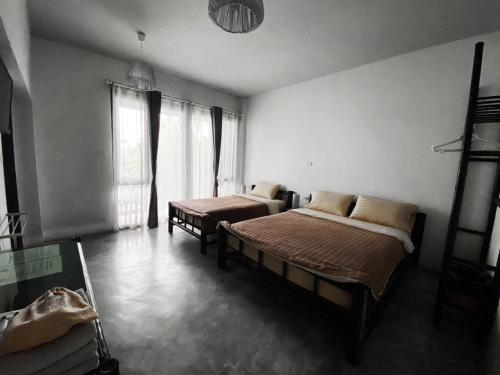 a bedroom with two beds in a room at Lamphu House Chiang Mai in Chiang Mai
