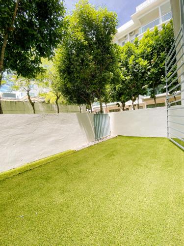 a backyard with a white fence and grass at Maison life 小居屋 The Loft Imago in Kota Kinabalu